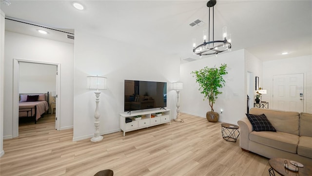 living room featuring light hardwood / wood-style flooring and a notable chandelier