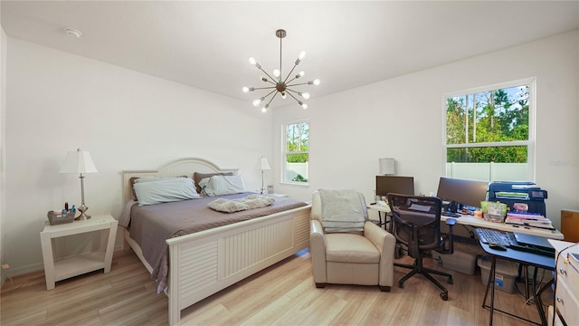 bedroom featuring light wood-type flooring, multiple windows, and an inviting chandelier