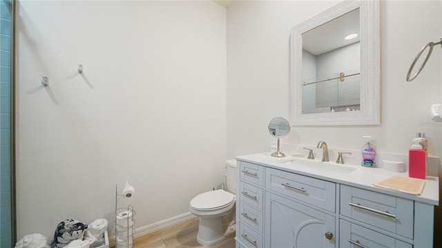 bathroom featuring toilet, vanity, hardwood / wood-style floors, and walk in shower