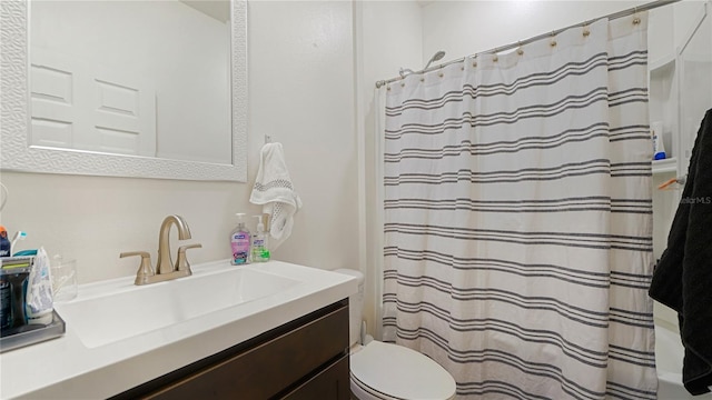 bathroom with vanity, curtained shower, and toilet