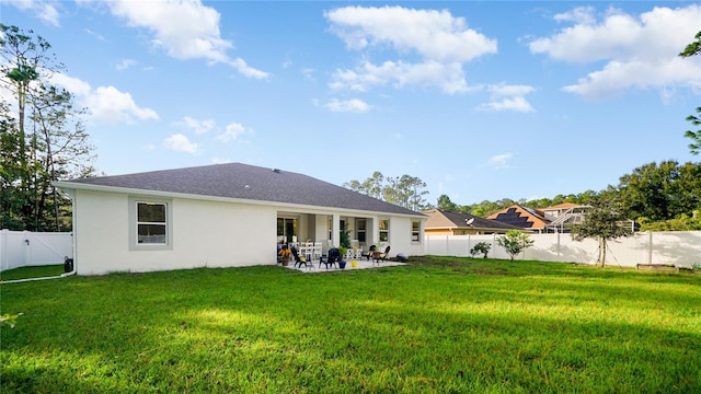 rear view of property featuring a patio area and a yard