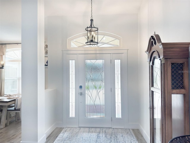 entrance foyer featuring a chandelier, a wealth of natural light, and light hardwood / wood-style flooring