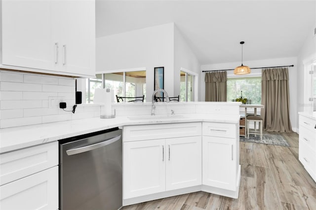 kitchen featuring dishwasher, a sink, vaulted ceiling, white cabinets, and light wood finished floors