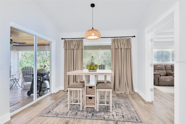 dining area with vaulted ceiling, plenty of natural light, wood finished floors, and baseboards
