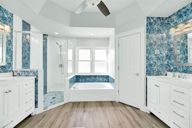 bathroom with vanity, hardwood / wood-style flooring, ceiling fan, and separate shower and tub