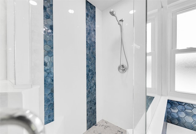 bathroom featuring tile patterned flooring and tiled shower