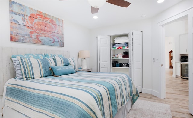 bedroom featuring light hardwood / wood-style floors, ceiling fan, and beverage cooler