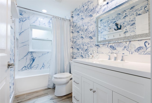 full bathroom with toilet, wood finished floors, vanity, shower / bath combo, and wallpapered walls