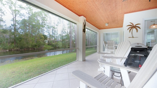 sunroom featuring a water view and wood ceiling