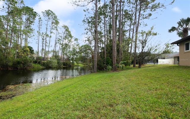 view of green lawn featuring a water view