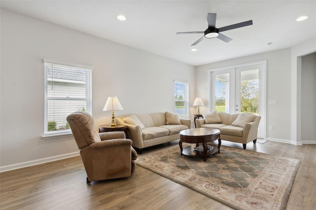 living room with hardwood / wood-style floors, a wealth of natural light, ceiling fan, and french doors