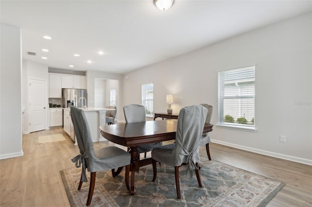 dining space featuring light hardwood / wood-style floors and a healthy amount of sunlight