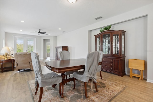 dining area with hardwood / wood-style floors, ceiling fan, and french doors