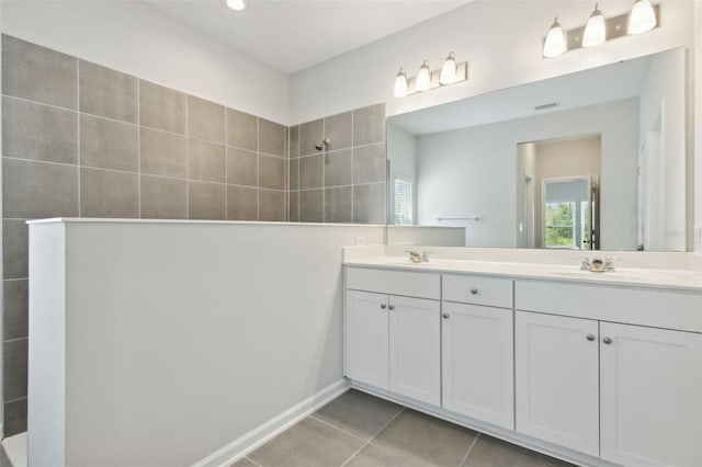 bathroom with vanity, tile patterned flooring, and a tile shower