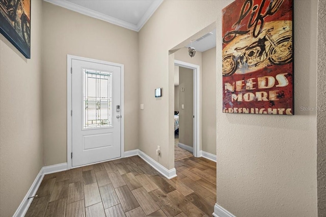 entrance foyer featuring ornamental molding and hardwood / wood-style floors