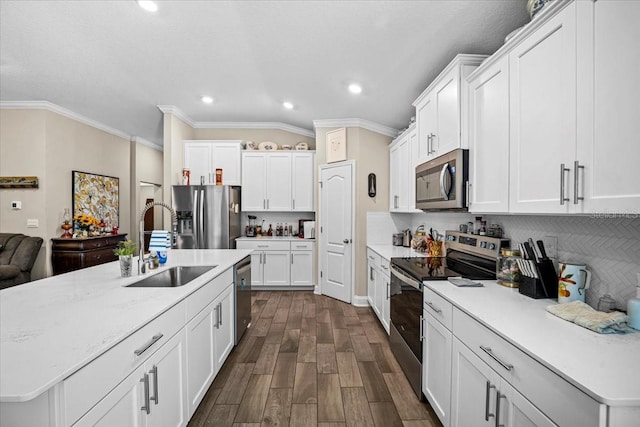 kitchen with appliances with stainless steel finishes, white cabinetry, a center island with sink, and dark hardwood / wood-style flooring