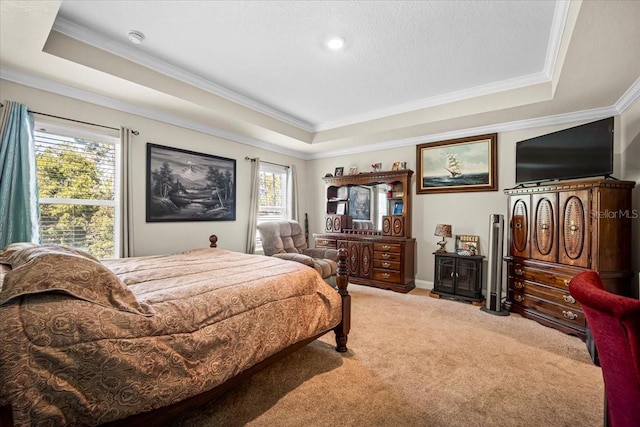 carpeted bedroom with multiple windows, a tray ceiling, and crown molding