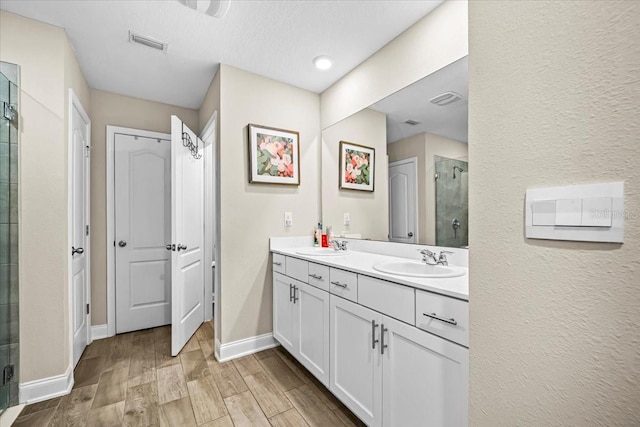 bathroom with vanity, wood-type flooring, and an enclosed shower