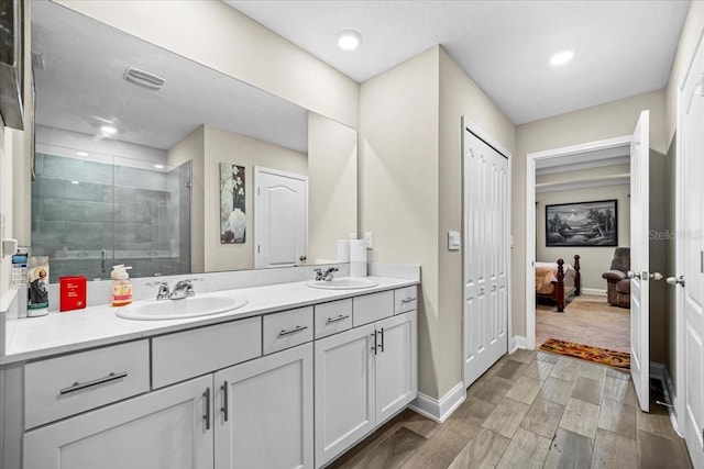 bathroom featuring vanity, wood-type flooring, and a tile shower