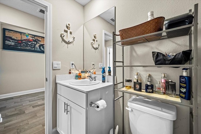 bathroom featuring vanity, toilet, and hardwood / wood-style floors