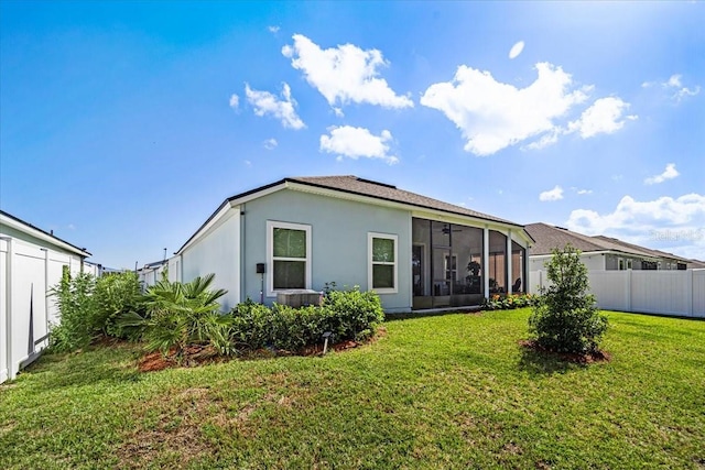 back of house featuring a lawn and a sunroom