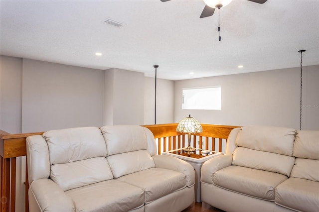 living room featuring a textured ceiling and ceiling fan