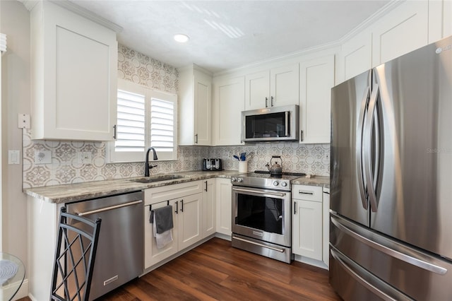 kitchen with appliances with stainless steel finishes, sink, and white cabinets