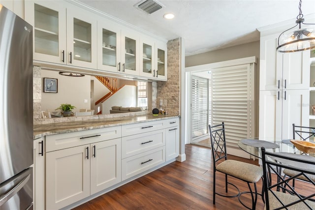 kitchen with dark hardwood / wood-style floors, stainless steel fridge, and white cabinetry