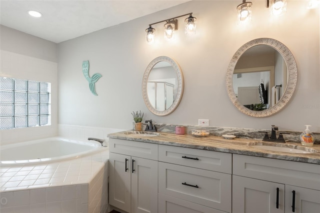 bathroom with vanity and a relaxing tiled tub