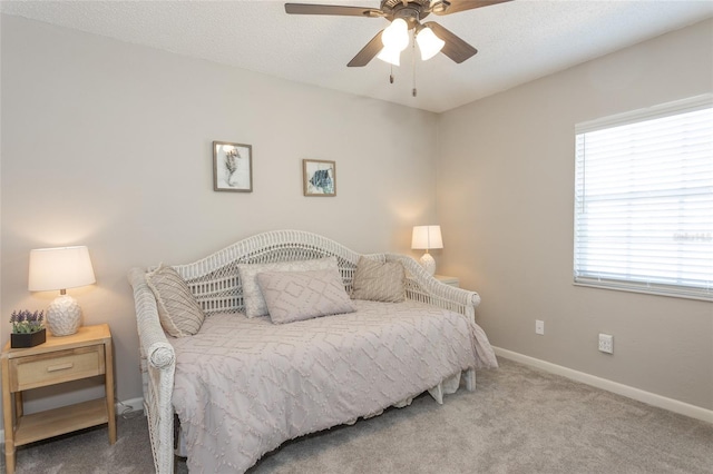 carpeted bedroom featuring ceiling fan and a textured ceiling