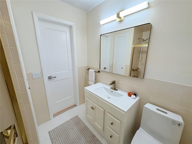 bathroom featuring walk in shower, vanity, tile walls, and toilet