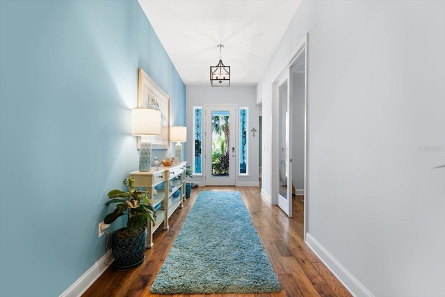 doorway with french doors, an inviting chandelier, and dark hardwood / wood-style flooring