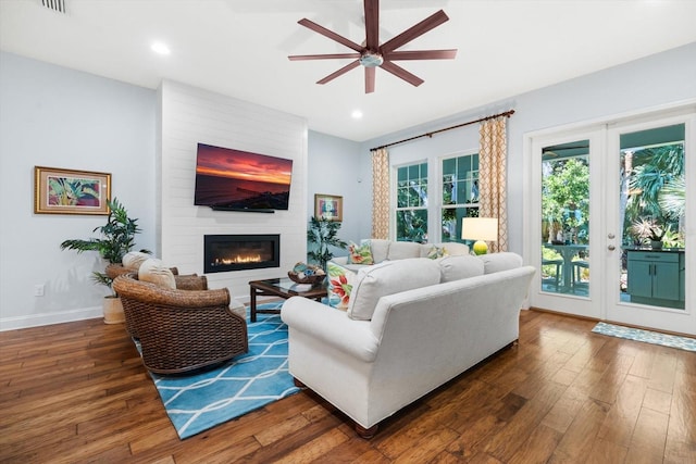 living room with a fireplace, dark hardwood / wood-style floors, and ceiling fan