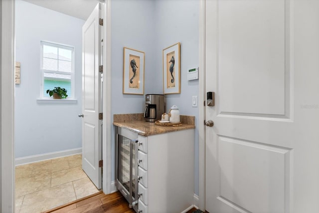 interior space featuring wine cooler, hardwood / wood-style flooring, and white cabinets