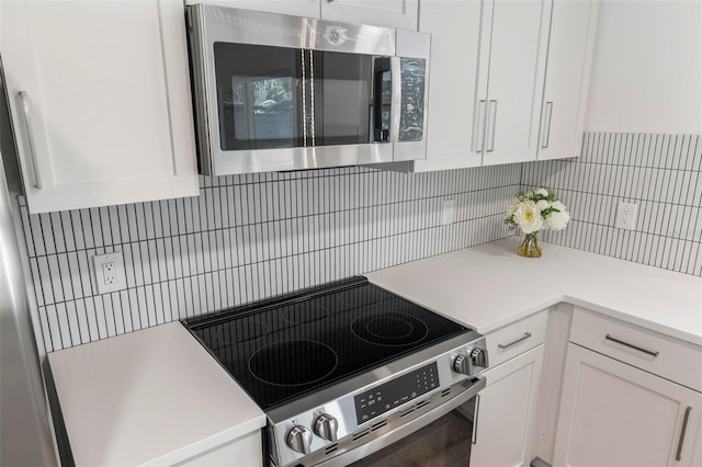 kitchen featuring white cabinets, backsplash, and appliances with stainless steel finishes