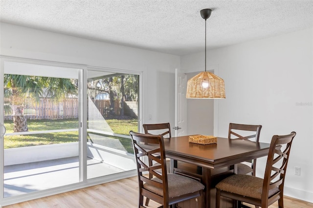 dining room featuring a textured ceiling and light hardwood / wood-style floors