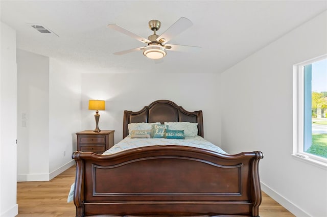 bedroom with multiple windows, ceiling fan, and light wood-type flooring