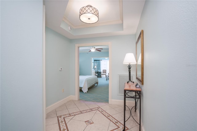 hallway featuring carpet floors and a raised ceiling