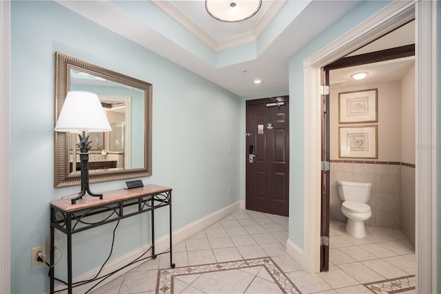 tiled foyer entrance featuring tile walls and crown molding