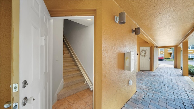 hallway with light tile patterned flooring and a textured ceiling