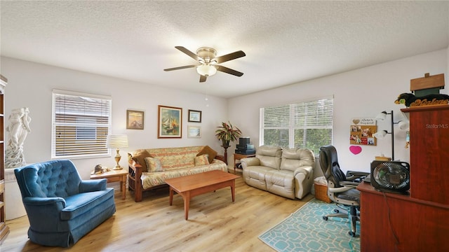 living room featuring a textured ceiling, light hardwood / wood-style floors, and ceiling fan