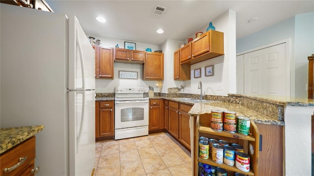 kitchen featuring kitchen peninsula, sink, light tile patterned flooring, light stone countertops, and white appliances