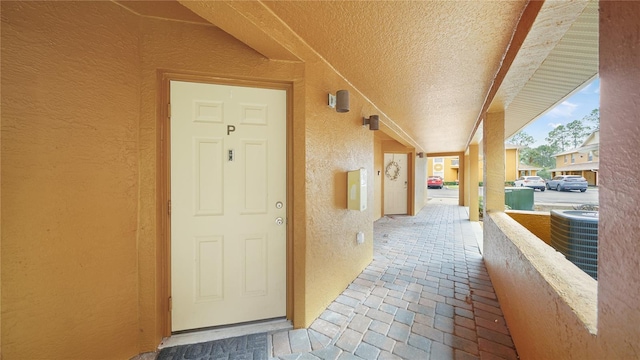 property entrance featuring central air condition unit and covered porch