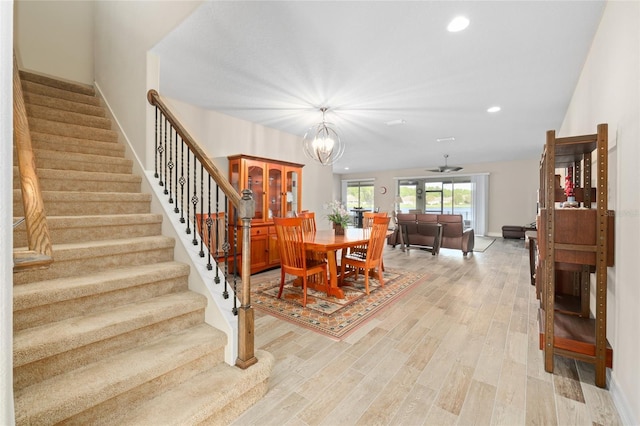 dining room featuring light wood-style flooring, recessed lighting, stairway, and baseboards