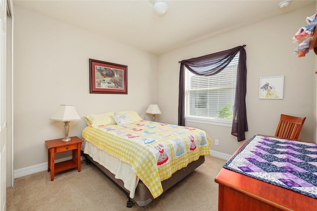 bedroom with light carpet and baseboards