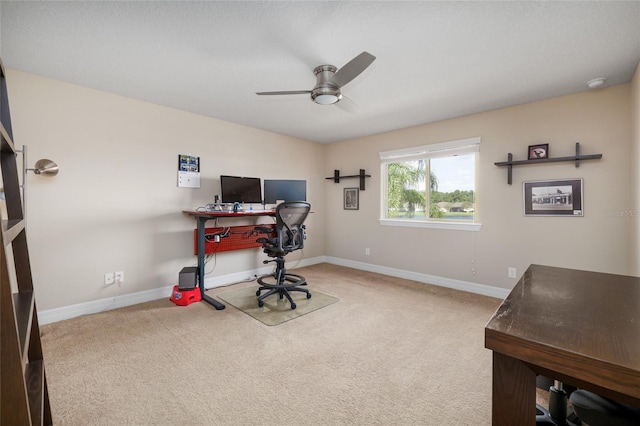 carpeted office featuring ceiling fan and baseboards