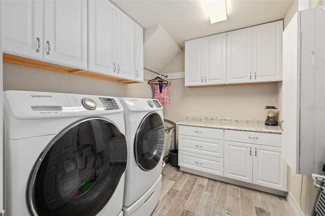 washroom featuring washing machine and dryer, cabinet space, and wood tiled floor