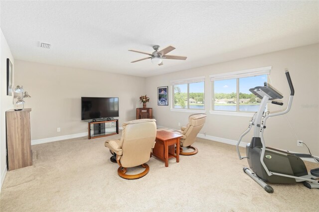 interior space with visible vents, a ceiling fan, carpet flooring, a textured ceiling, and baseboards