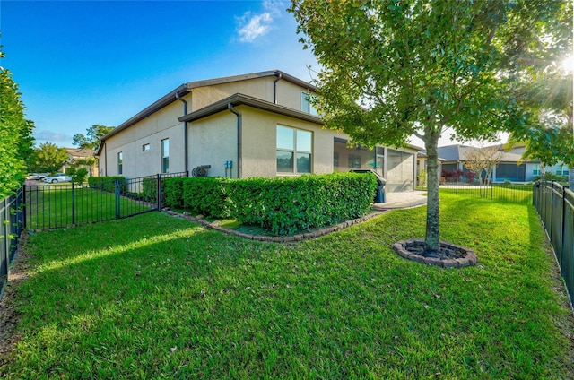 view of side of home featuring a fenced backyard, a lawn, and stucco siding