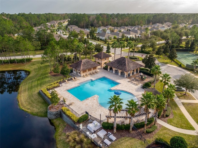 community pool featuring a patio, a water view, a gazebo, fence, and an outdoor structure